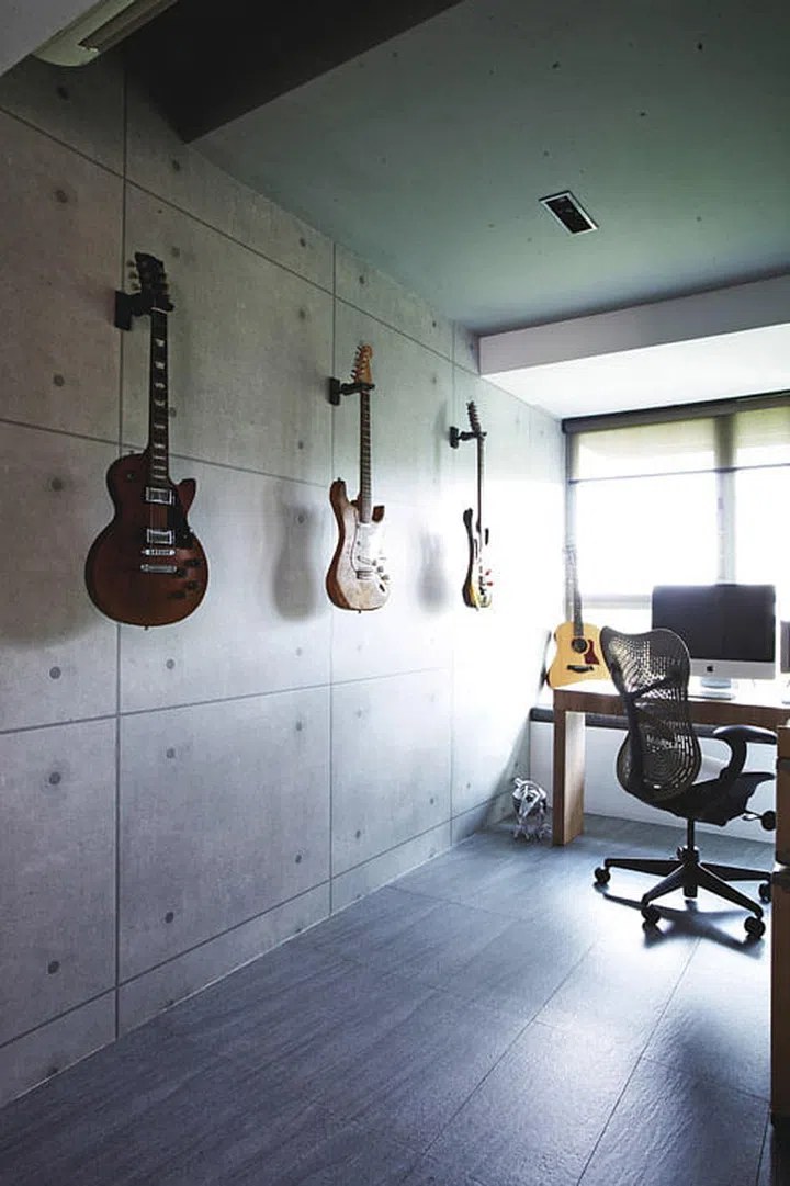 Homeowner, Gina, works from home, sharing the study with her husband’s instruments. The ceiling in a dove grey echoes the concrete wall.