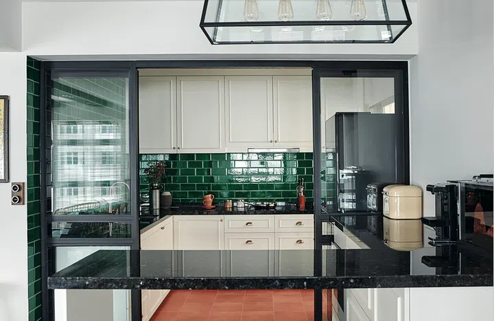 Jade green subway tiles and terracotta-look floor tiles, purchased from Hafary, make this open-concept kitchen a cheery space. Interior Design: M3 Studio