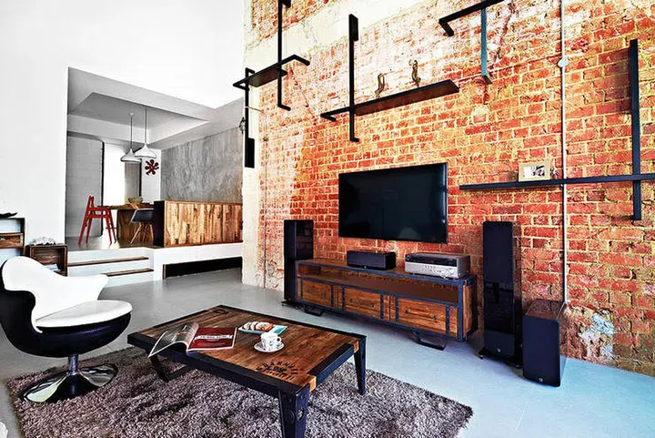 The homeowners enhanced the living room’s industrial theme with a coffee table and TV console from Journey East. Interior design by Space Sense