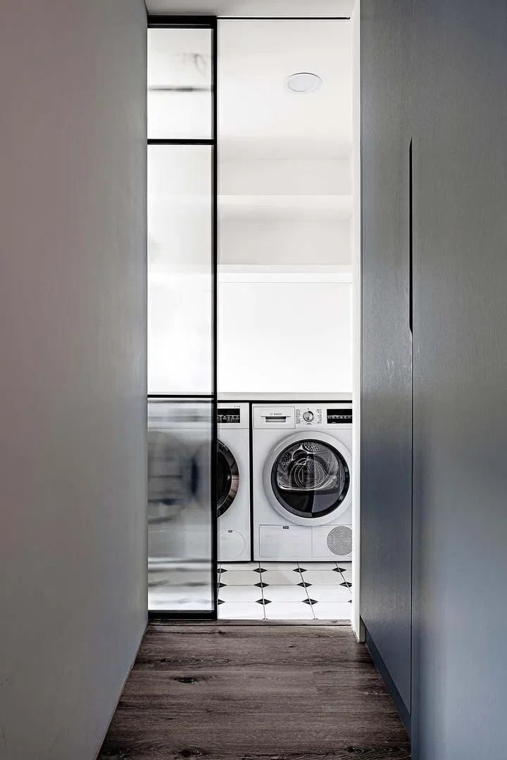 The utility area is concealed behind a sliding fluted glass panel door.