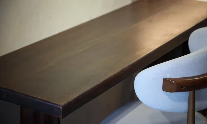 The dining tabletop, which doubles as a bar counter, woodworked by the couple.