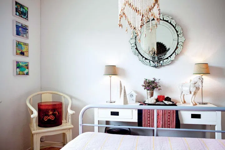 The master bedroom conveys a quiet air, with subtle yet interesting accessories like a wind-catcher made of shells and a cream-coloured, Oriental-style armchair. 