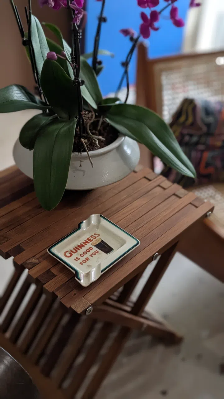 A wooden table with a fun ashtray-meets-trinket bowl.
