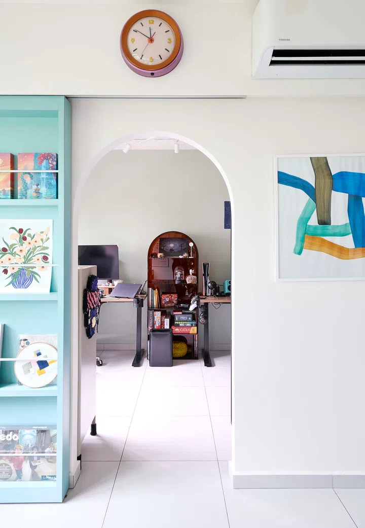 The hidden study with the turquoise magazine rack sliding door fully open, revealing the workspace inside.