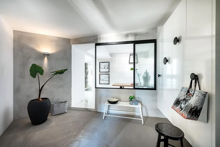 Looking in from the entrance foyer, the black-framed window captures part of the dining room like a picture.