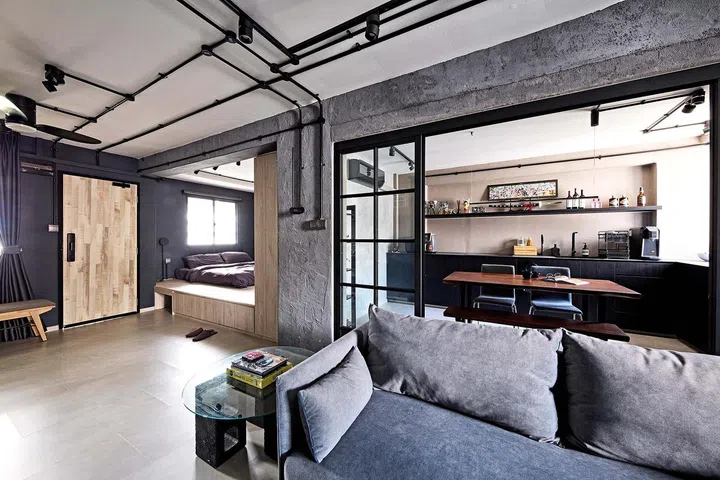 Cement screed walls, exposed conduit trunkings and a platform bed were among some of his specific requests in flight attendant Kenny Shoo’s 3-room HDB flat at Tampines Street 41.