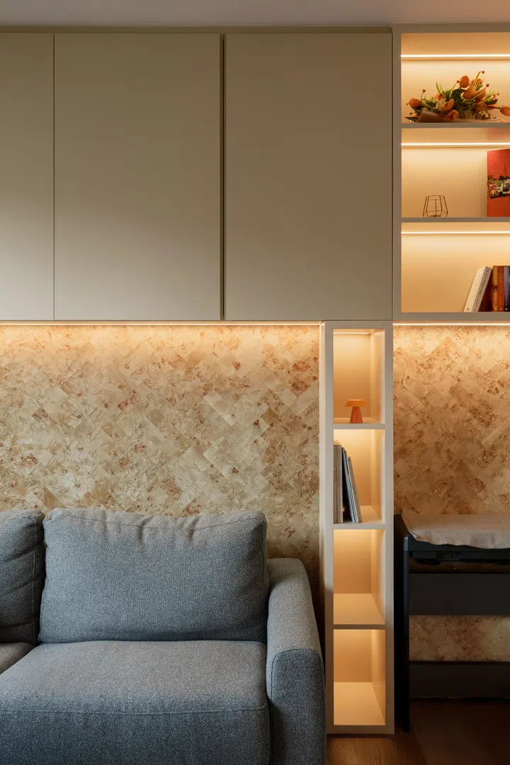 Integrated shelving and warm lighting give the multi-purpose room a relaxed, lived-in character rather than the feel of a room waiting to be used.