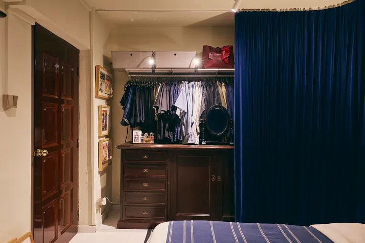 Instead of built-ins, the curtain conceals an open wardrobe neatly tucked within an existing nook.
