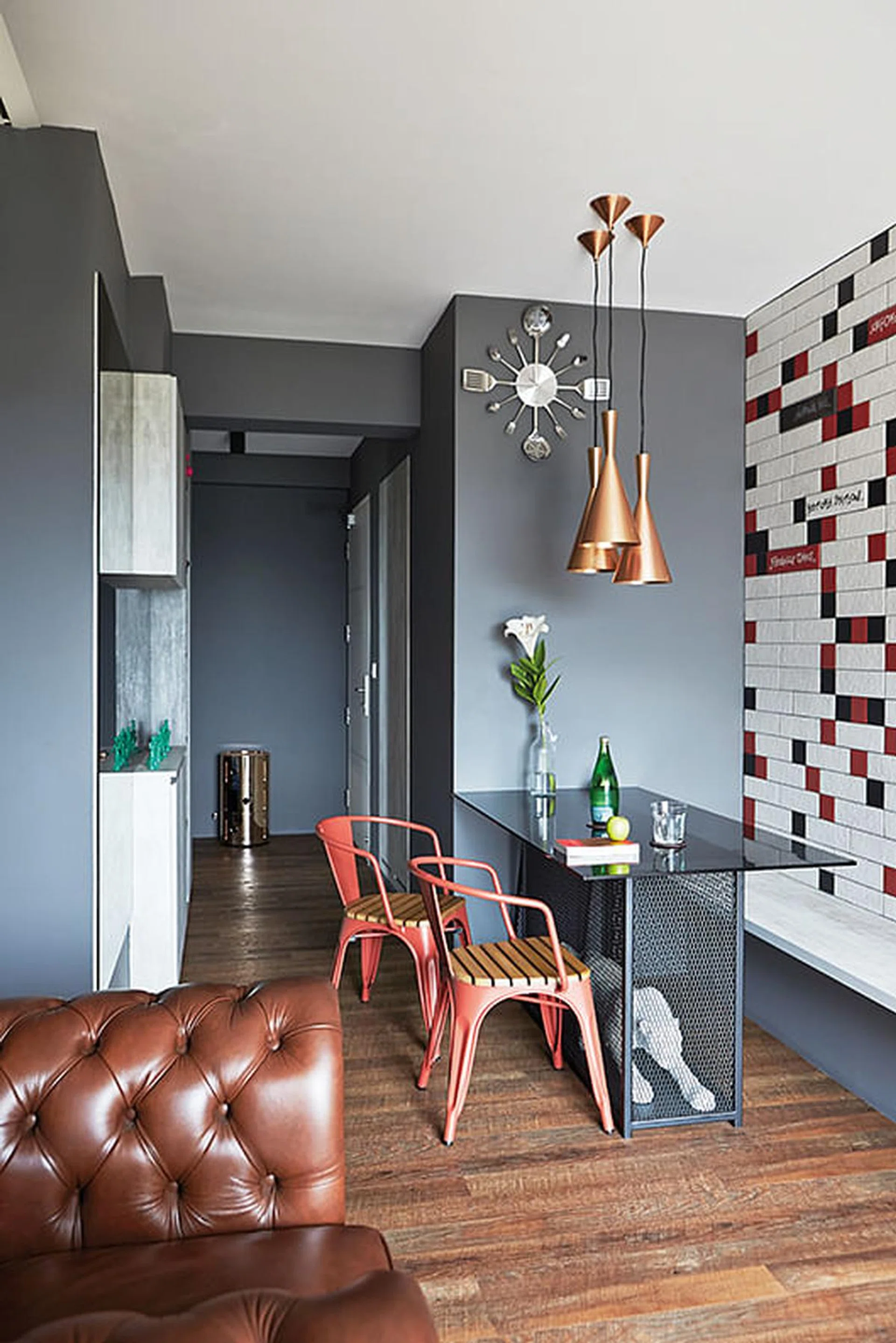 [Reno costs: $30,000] Statement pieces in different styles, such as the Chesterfield-style armchair, industrial-style dining chairs, and a leopard sculpture under the dining table, dress up this home. The clock hints at the homeowner's passion for cooking.