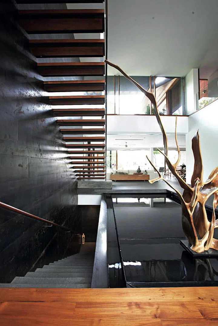 Golden sunlight and warm wood tones liven up the minimalist aesthetics of this 2-storey bungalow in Sentosa Cove.