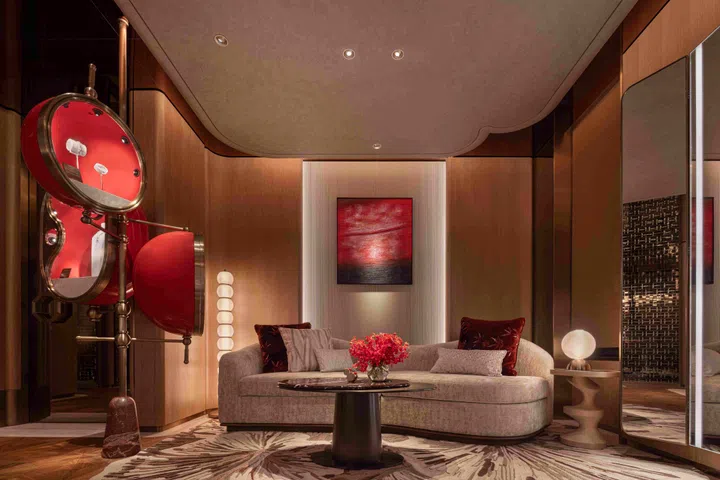Designed with a warm, residential feel, the upper floor VIP lounge features soft curved seating, tactile fabrics, and a palette of warm neutrals accented with deep Qeelin red. An oval swivel jewellery display allows guests to adjust the lighting angle of each piece during private viewings.
