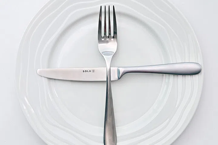 Utensils placed in a cross "t" signals to waiters that you're ready for the next dish.