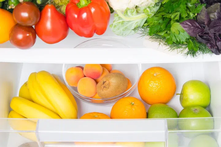 in a white refrigerator, food stock, fresh vegetables on the top shelf, and fruits on the bottom shelf
