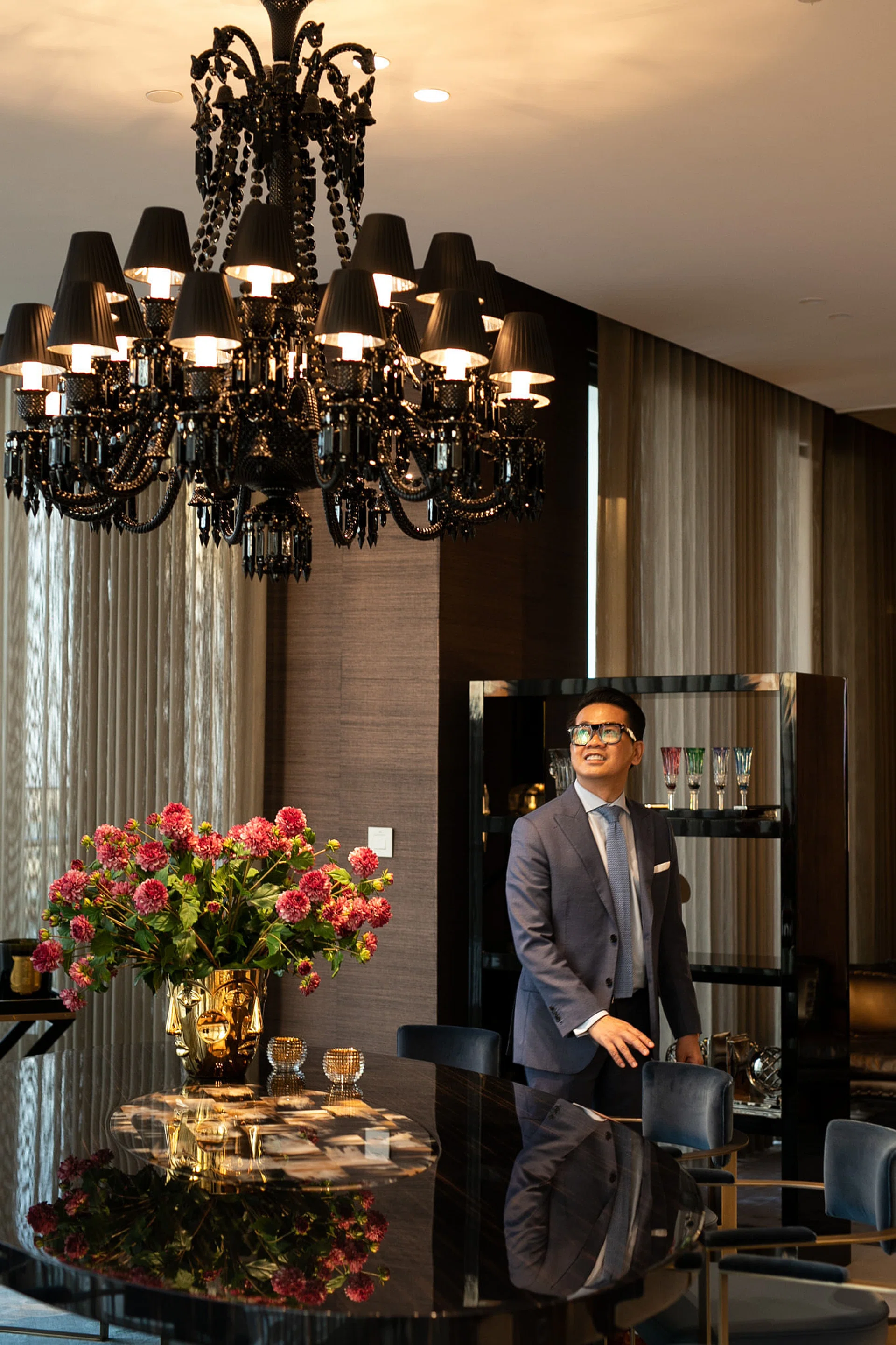 Interior designer Quach Thai Cong posing in a glamorous dining room.