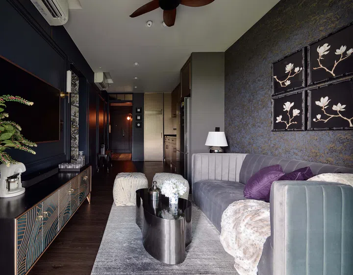 A mix of eclectic furniture and textured wallpaper gives the living room a refined, yet inviting atmosphere.