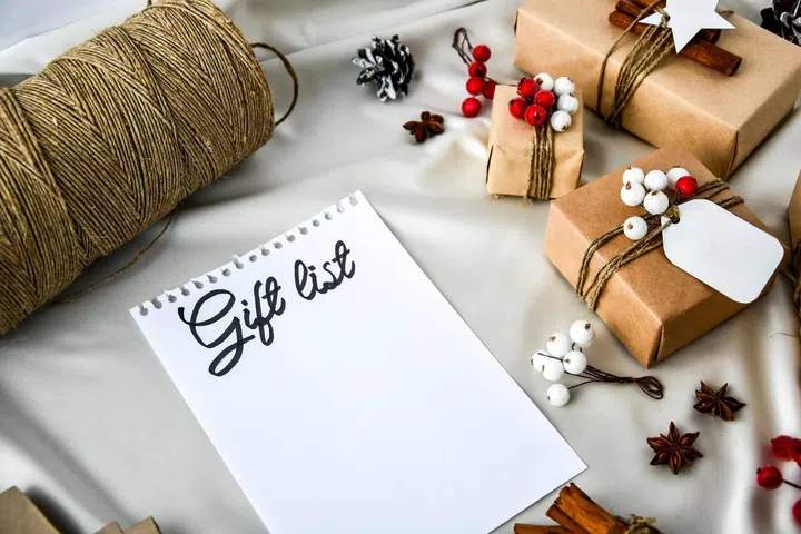 Notebook with GIFT LIST text Zero waste Christmas text with presents with decorations on champagne colored silk background. Copy space. Eco friendly packed gift with tags from craft cardboard. Image 123RF