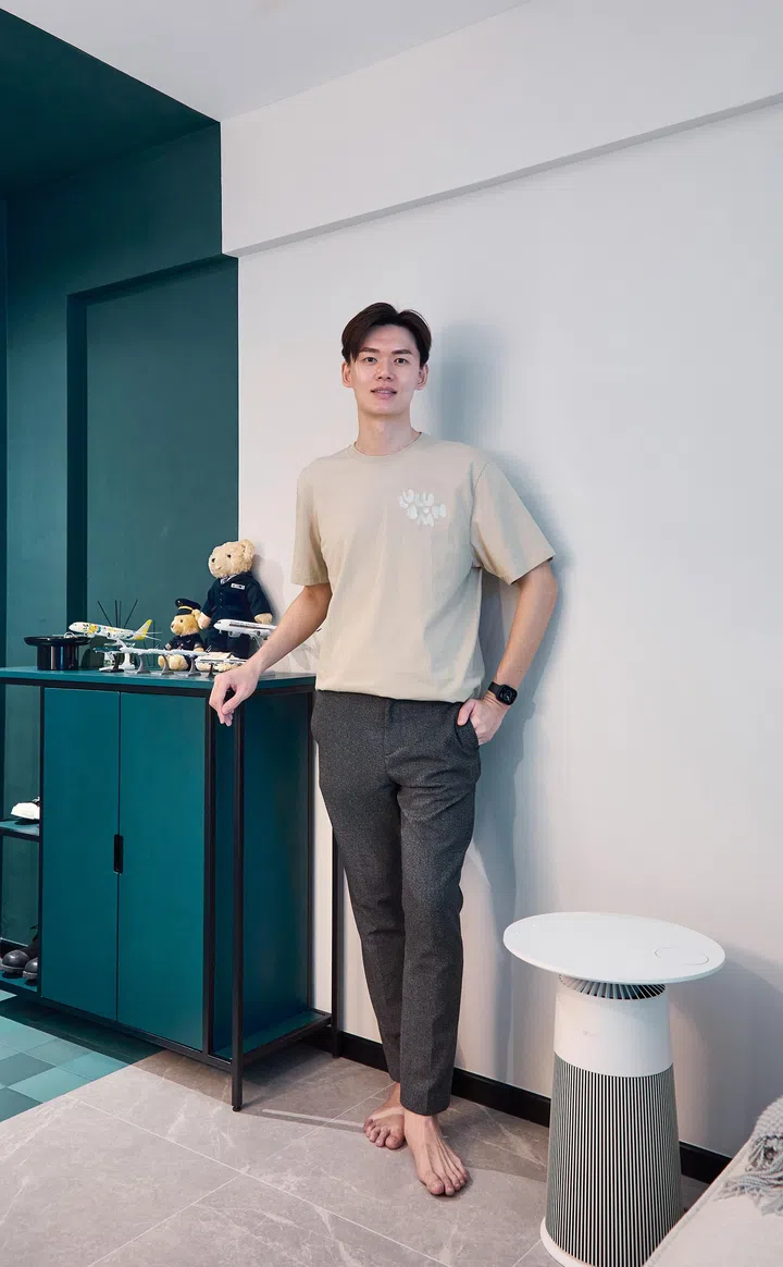 Duncan Chew standing in his thoughtfully designed flat, a blend of personal memories and minimalist style.