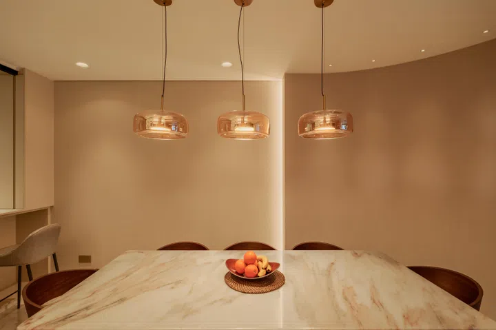 Positioned between the living room and kitchen, flanked by a curved wall, the dining area was conceived as a more intimate enclave.