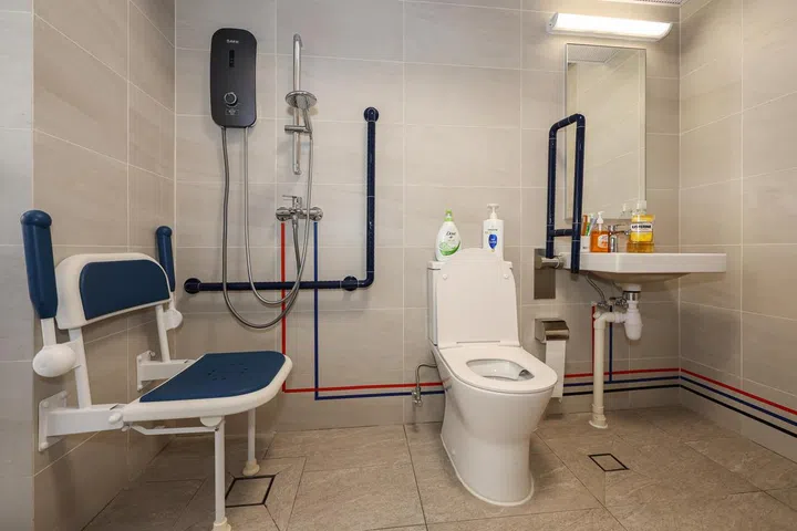 An overview of the bathroom in an apartment in Harmony Village @ Bukit Batok on Jan 7, 2025. It is retrofitted with grab rails and even a chair to assist the elderly with mobility issues to shower. 