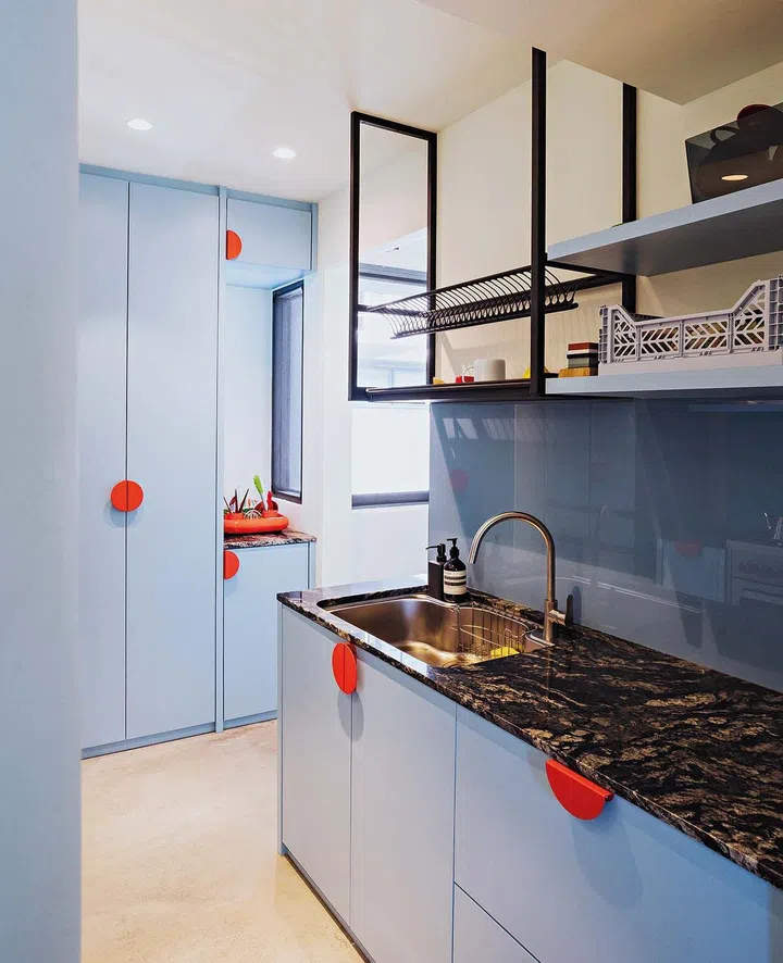 The orange handles, sourced from the kids’ section in Ikea, add a surprising and playful touch to the kitchen.