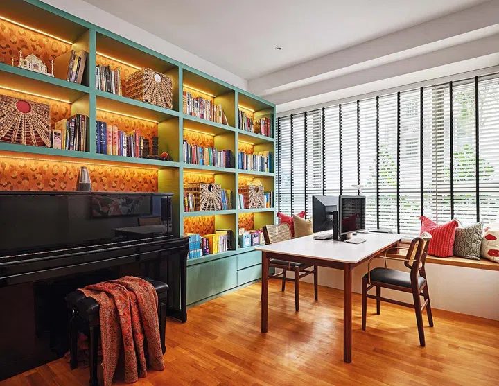 The retro-inspired colour palette of sage green carpentry and leopard-print wallpaper serves as an eye- catching Zoom call background for Melvyn in this home office.