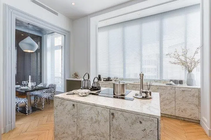 The kitchen, with counters clad in elegant beige granite, opens with sliding laminated glass doors and segues into the dining room.