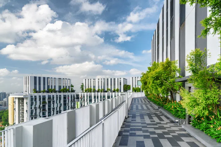 Amazing rooftop garden. Scenic outside terrace with park and beautiful city view. Modern benches under green trees along walkway. Urban eco design and mini-ecosystem. Landscaping in Singapore.