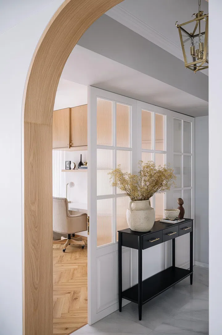 Fluted glass door envelope the study room in this 2-bedroom apartment in Parsi, Mumbai.