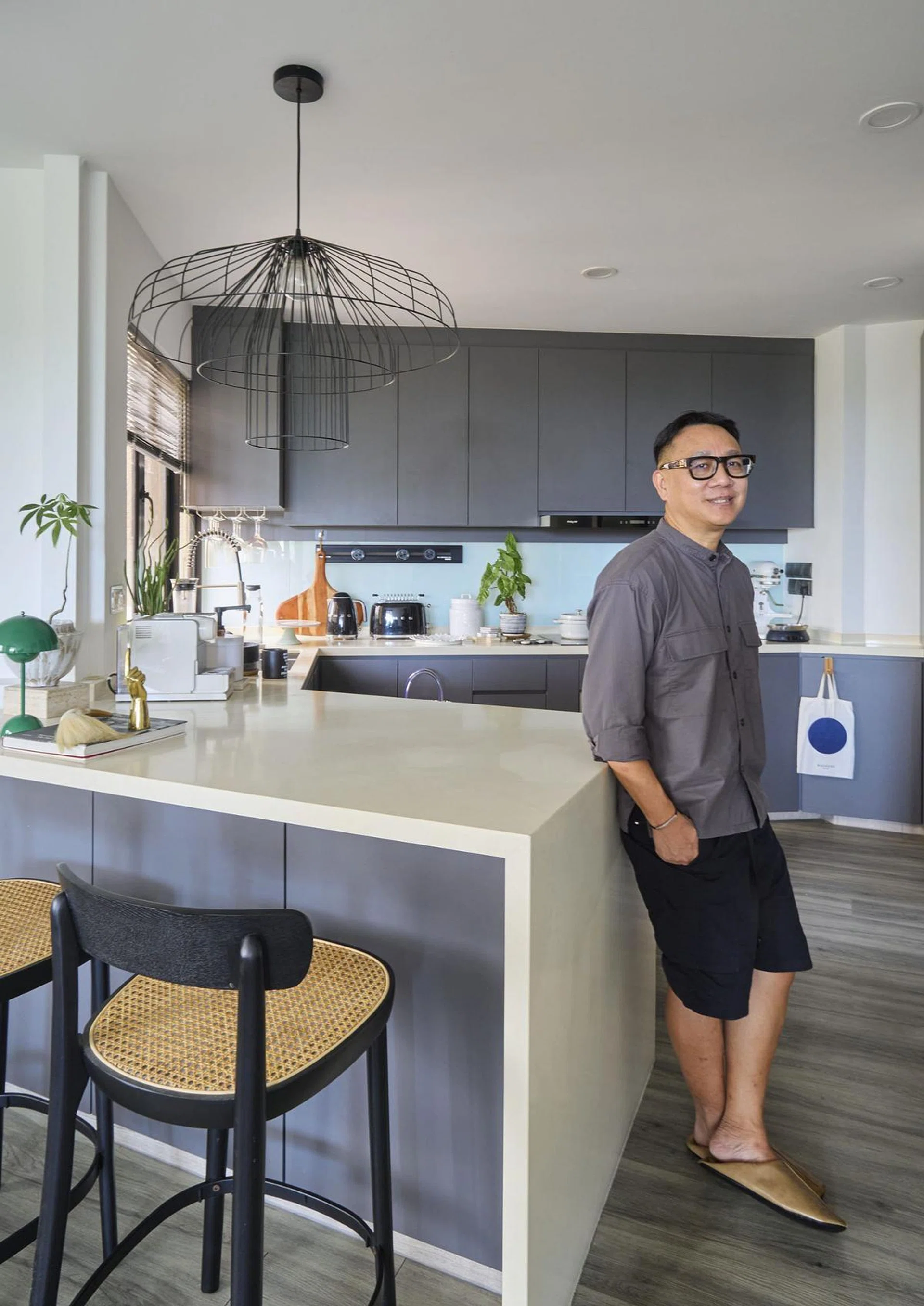 Mike Tan is the owner of Eggthree poses for a portrait in his 2-bedroom condominium in Bayshore Park.