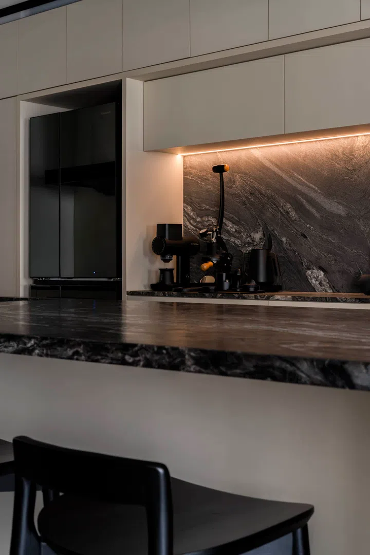 The island doubles as a social hub, with appliances tucked discreetly into the wall behind.