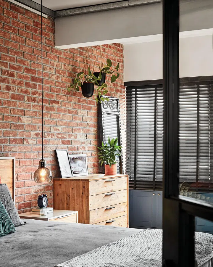A pendant light that hangs low above the bedside table aligns with the industrial style.