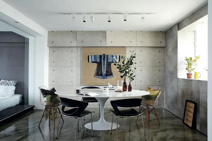 The mismatched seats give the dining area a laid-back air. The "concrete screed" wall is actually a wallcovering!