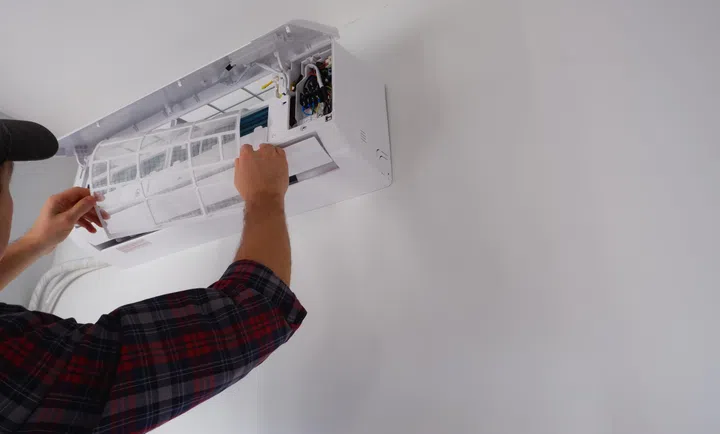 Air conditioner repair and maintenance. The engineer of the service organization carries out maintenance of the indoor unit of the air conditioner. Cleaning the filters.