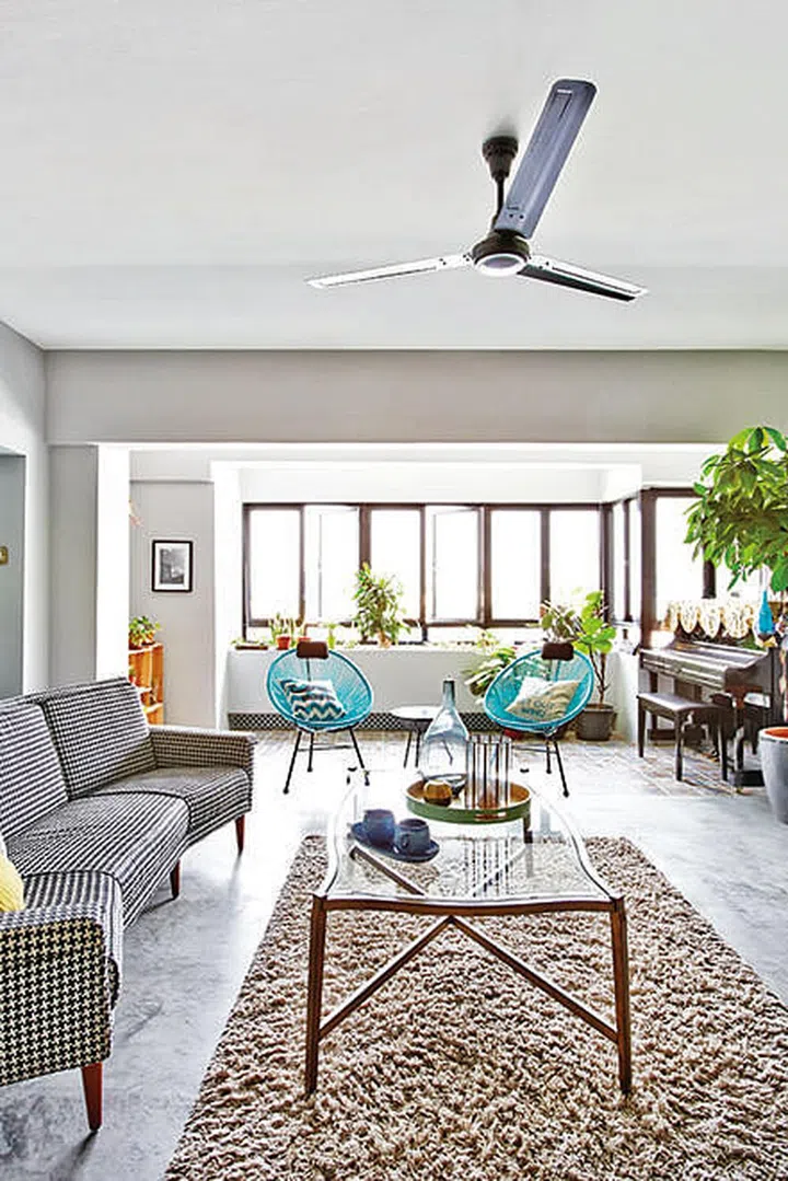 The home's light-coloured palette, which includes the polished cement floor, shows off the colourful furnishings. 