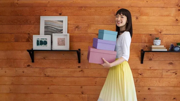 Marie Kondo carrying organisation boxes