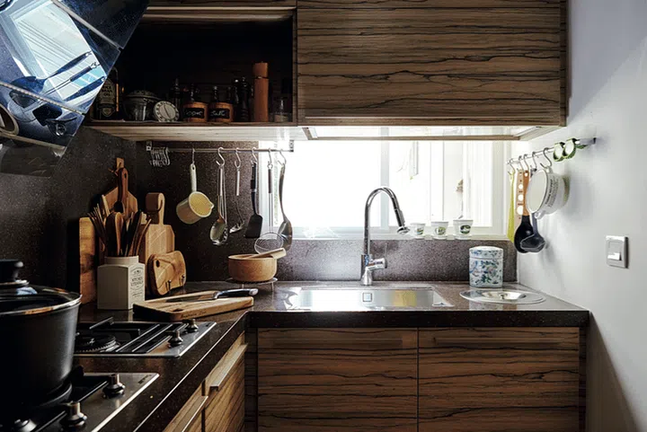 Kitchen tools are kept off the countertop with the use of rails and hooks, freeing up workspace.
