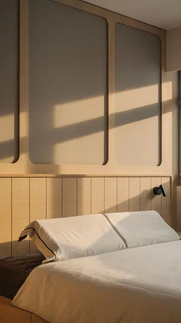 Sunlight bathes the wooden master bed headboard in a 4-room HDB in Punggol.