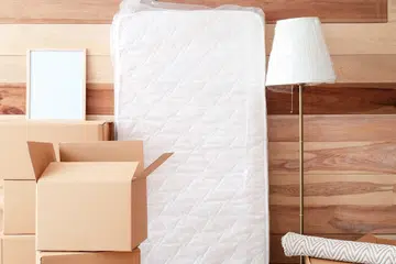 Cardboard boxes with belongings in new flat on moving day.
