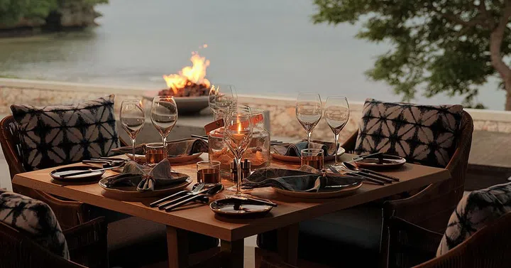 Raffles Bali - Loloan Beach Bar and Grill candle light dinner by the beach table setup