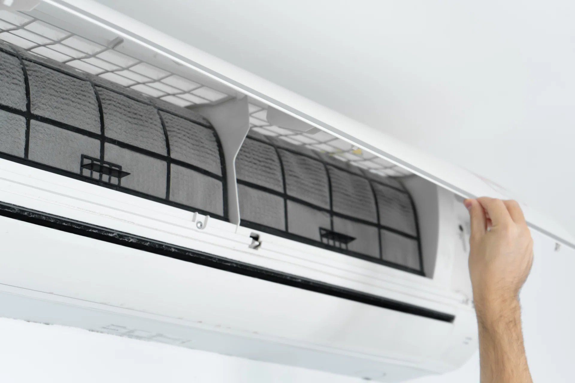 A guy cleans the filter of the home air conditioner from dust. Very dirty air conditioner filter. Climate equipment care.