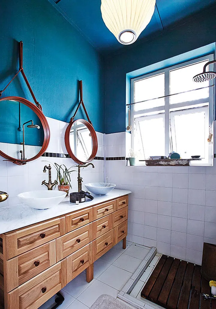 The only bathroom in the home gets a regal treatment with a splash of blue-green, paired elegantly with a couple of Gubi mirrors and antique-inspired brass taps which Nathan found from a shop in Geylang.