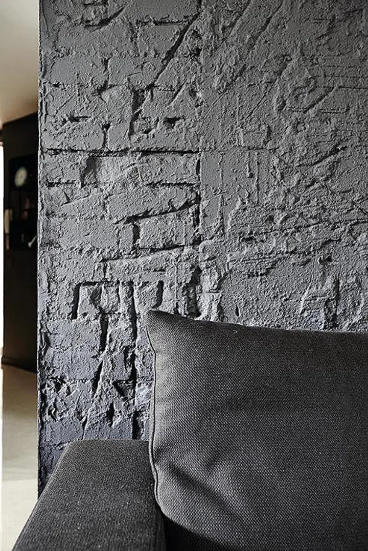 Use different textures to add interest to a monochromatic palette. Here, grey is the main colour used, but textures range from the roughness of the brick wall treatment to the subtle quality of the sofa.
