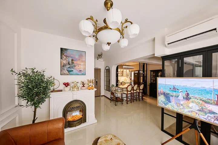 The living area sets a European-inspired tone with an ornate electric fireplace and statement chandelier.
