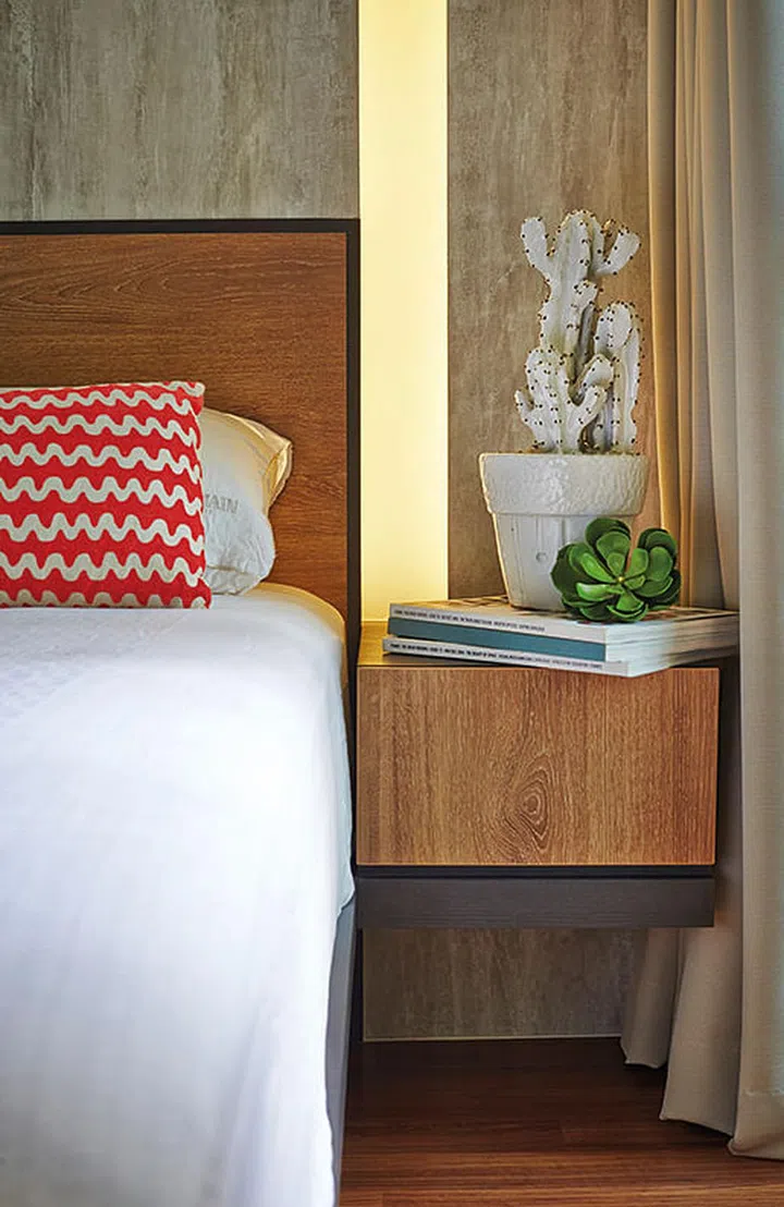 Instead of using a bulky side table lamp, recessed lighting was built into the wall to reduce clutter in the master bedroom.