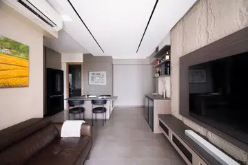 The living room with a stone textured wall leading to the home bar area.