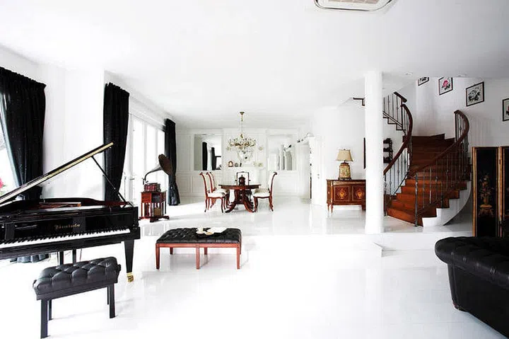 The piano and gramophone add a nice touch to the simple, classical interiors of this home. Design by The Cottage Crafts
