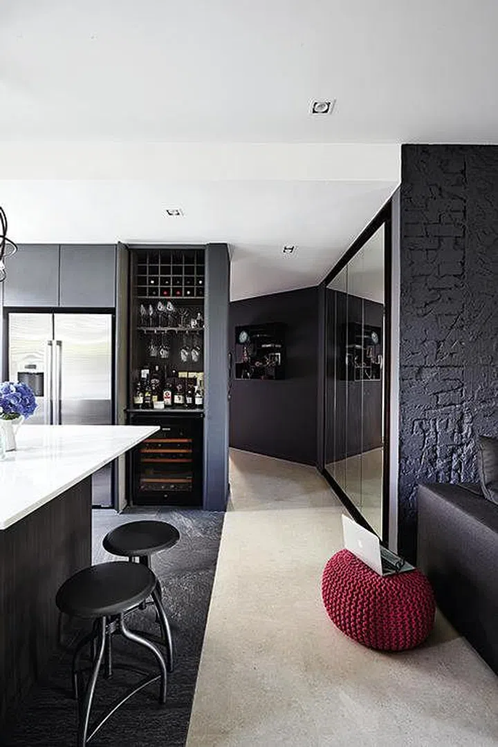 The walls of the apartment are lined with generous storage space.
The deep bar counter houses a wine fridge and can be hidden when not in use.