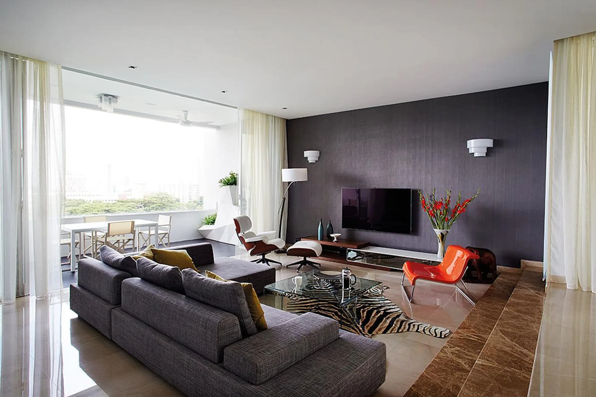 The moody shades of the sunken living room balances out the home's bright and breezy feel.