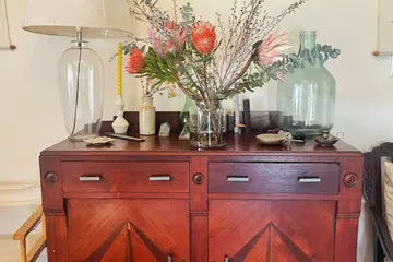 A Mid-Century Modern sideboard in my home, where dinner and servingware are stored away in an open-plan dining and living area