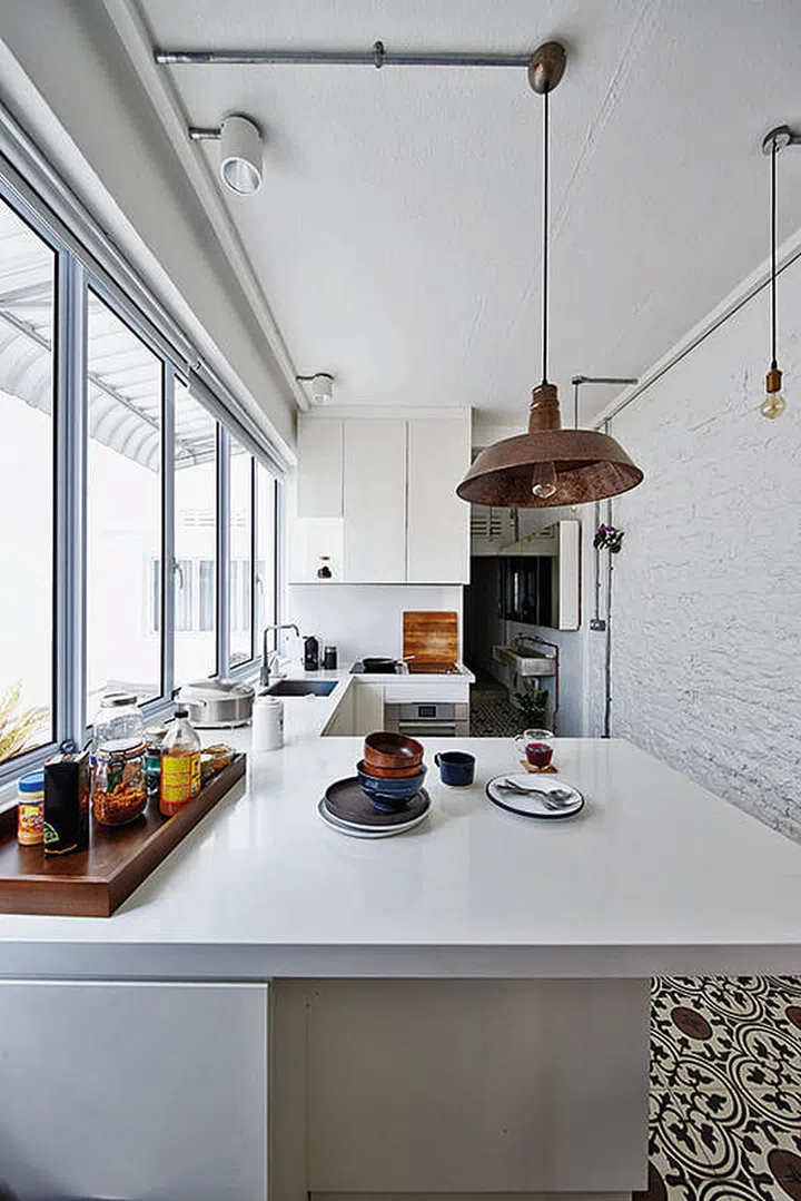An all-white palette allows for a bright and airy feel in the compact kitchen.